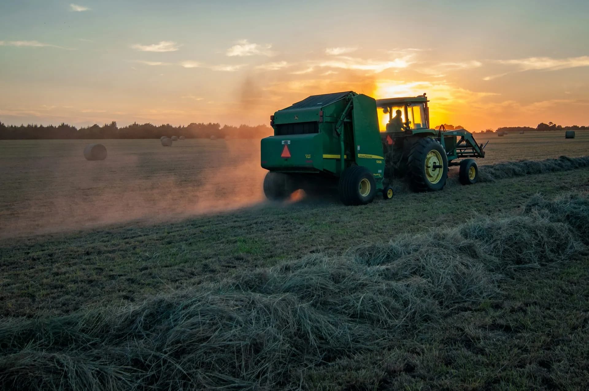 Tractor working in a field at sunset